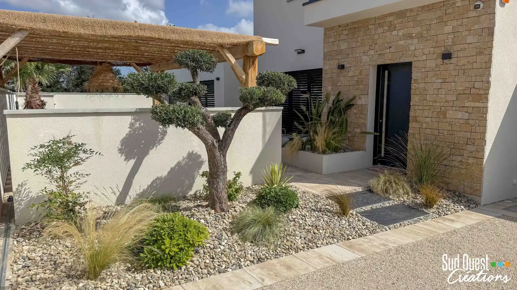 Aménagement de jardin de maison neuve avec terrasse bois, pergola et allée en castine à Toulouse