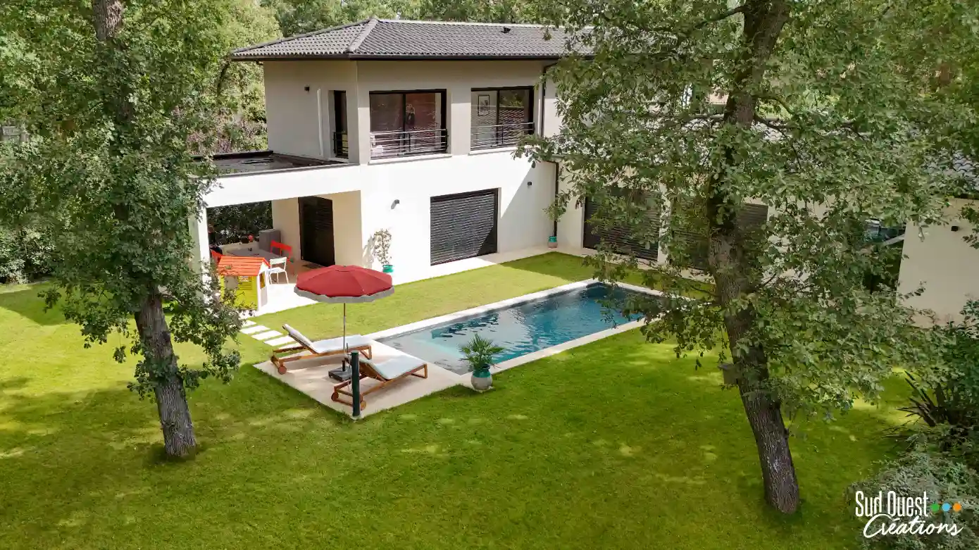 Aménagement de piscine 8x4m avec muret de soutènement en pierre et enrochement paysager à Lacroix-Falgarde.