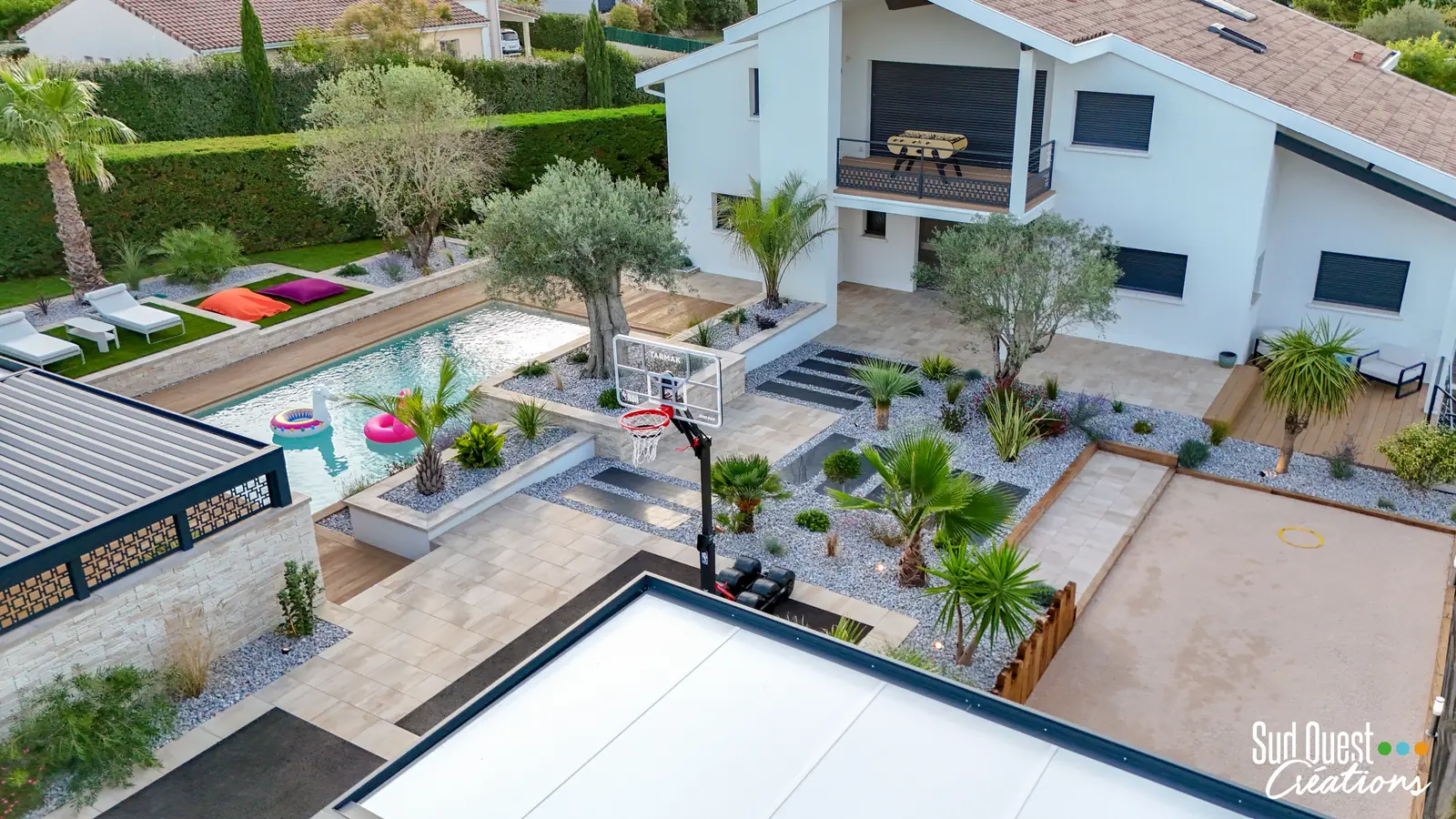 Vue drone d'un aménagement complet : piscine, olivier centenaire, jardin sec, terrain de pétanque et carport