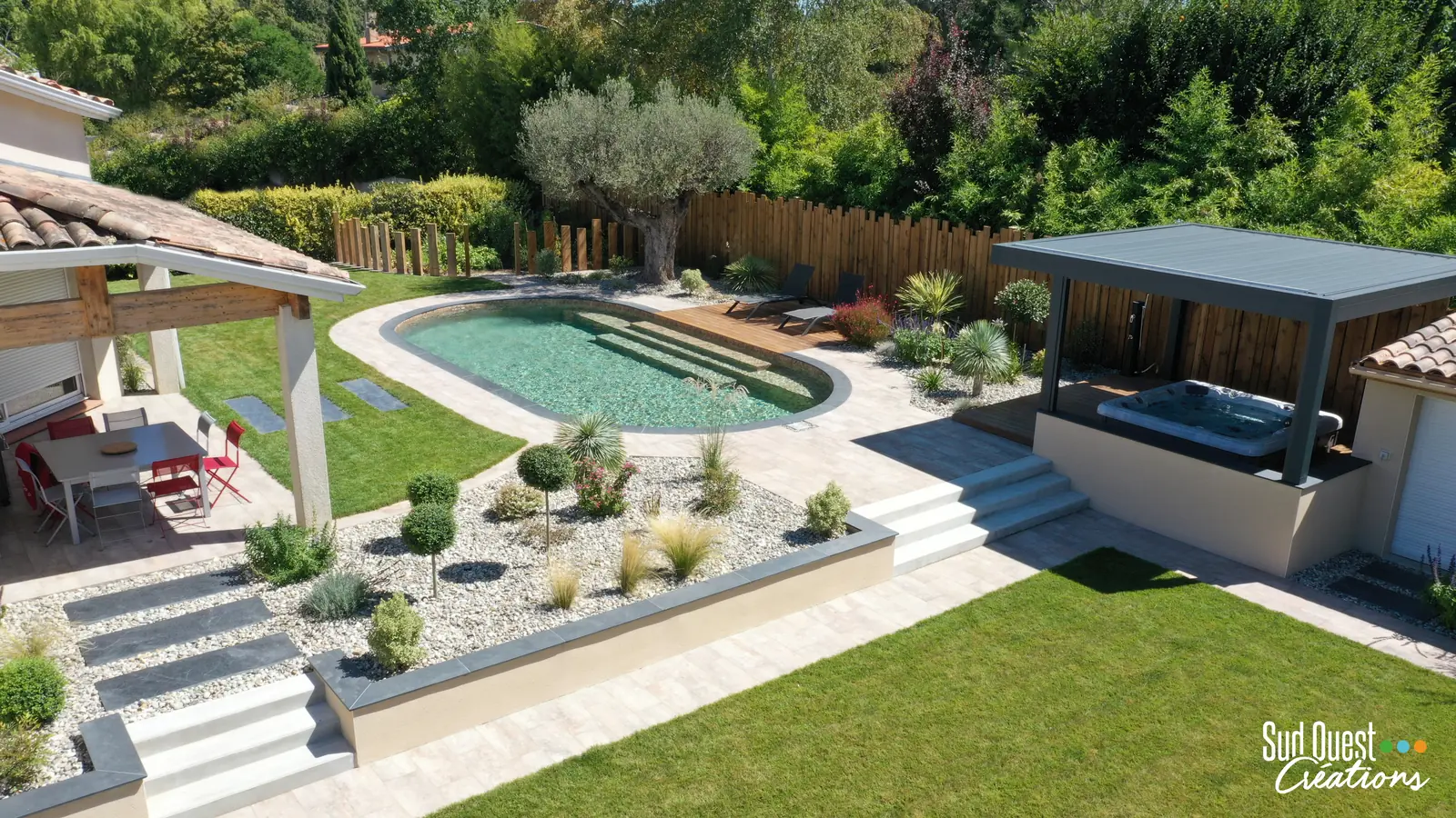 Vue aérienne d'un aménagement complet : piscine ovale, murets, escaliers, massifs et spa sous pergola