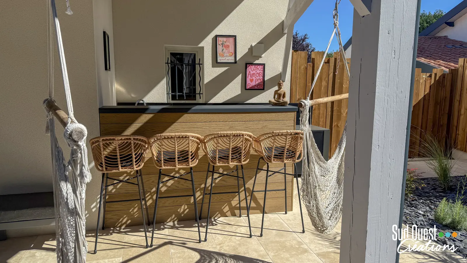 Bar extérieur sous auvent bois avec tabourets en rotin et hamacs