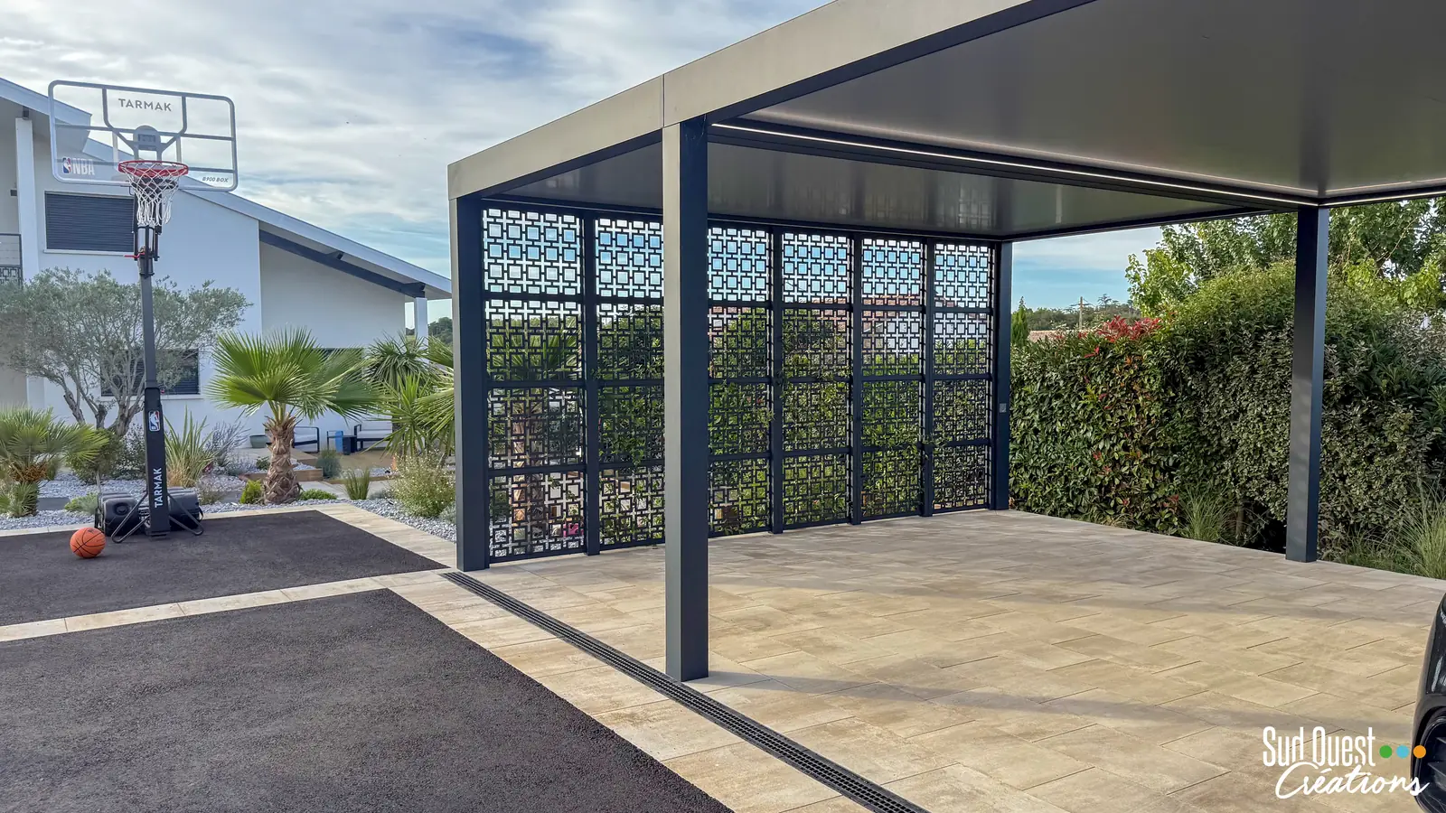 Carport en pergola bioclimatique aluminium avec panneaux en métal découpé et éclairage LED