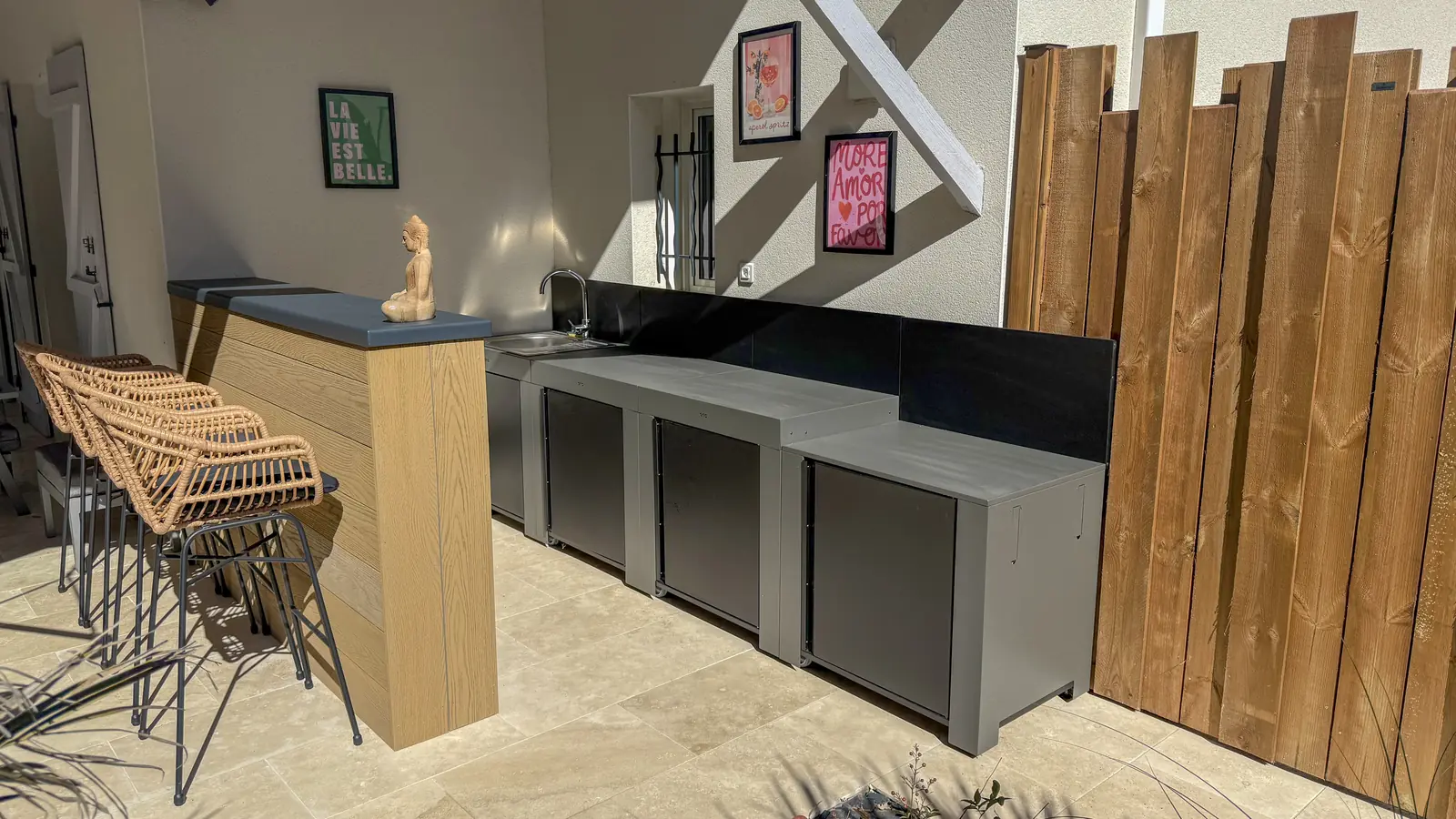 Cuisine d'été modulaire avec évier et bar habillé de composite sur terrasse en travertin