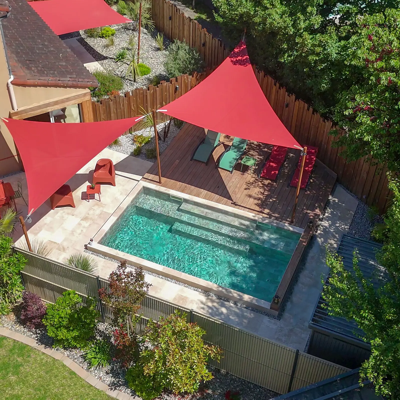 Petite piscine de jardin de ville avec terrasse bois et clôture bois, vue drone