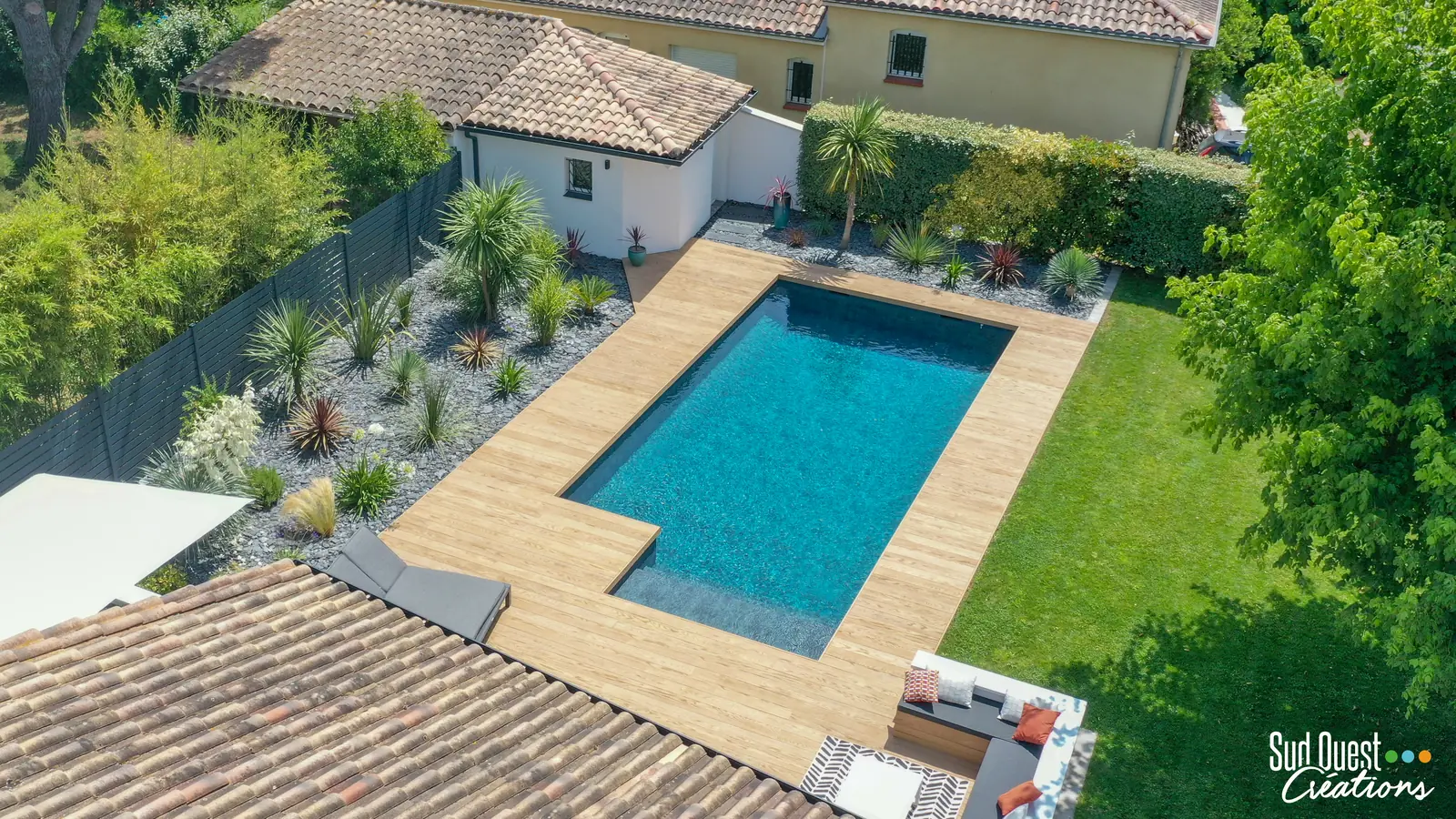 Vue drone d'une piscine avec terrasse composite, massif exotique et clôture aluminium