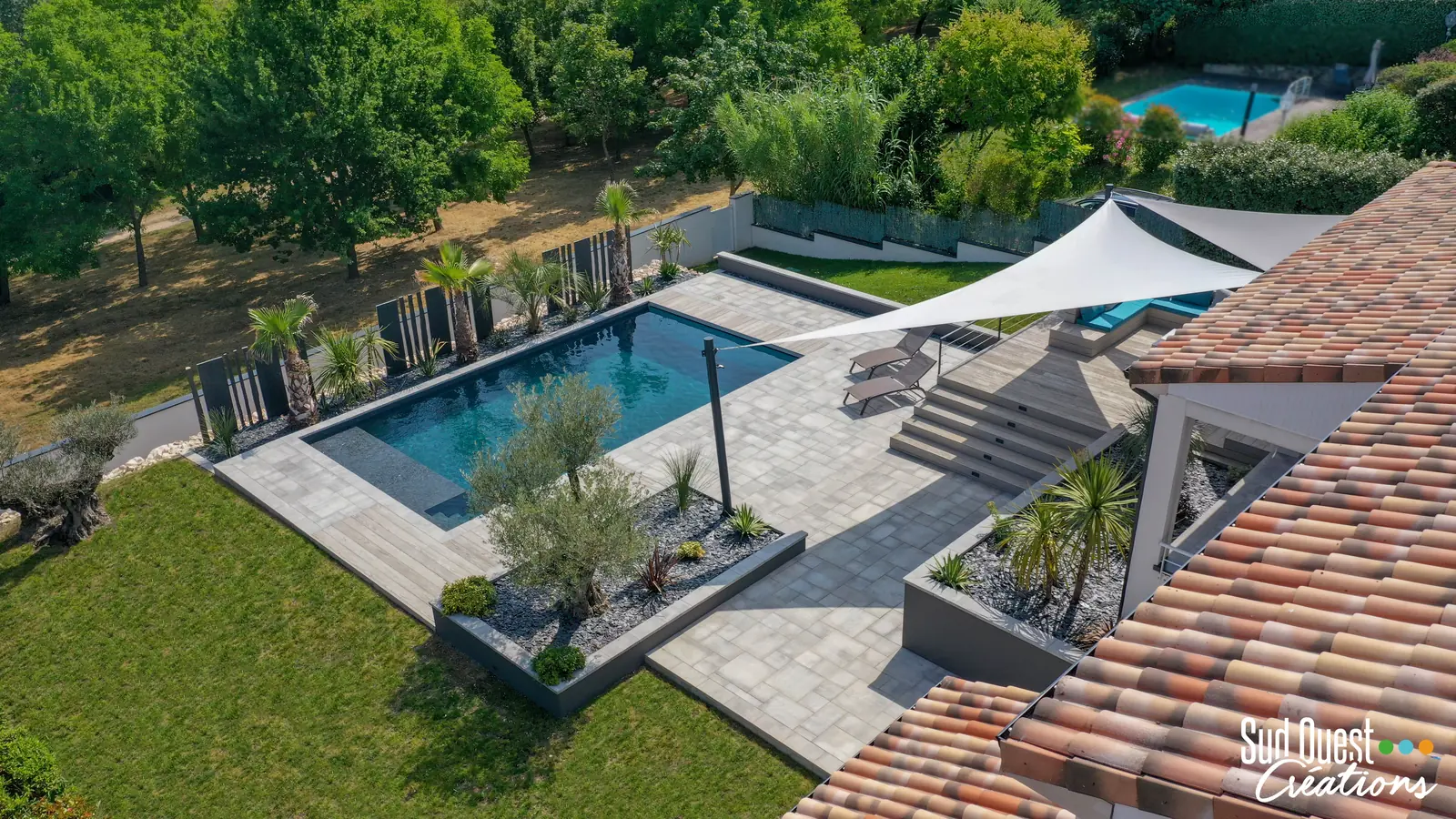 Vue drone d'une piscine, jardinière avec olivier, escalier composite et voiles d'ombrage