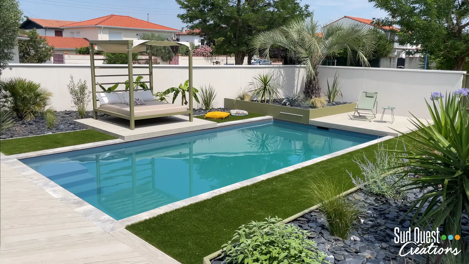 Piscine rectangulaire bordée de gazon synthétique avec lit à baldaquin et jardinière