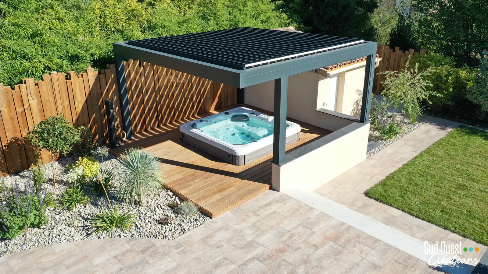 Spa encastré dans une terrasse bois sous une pergola bioclimatique